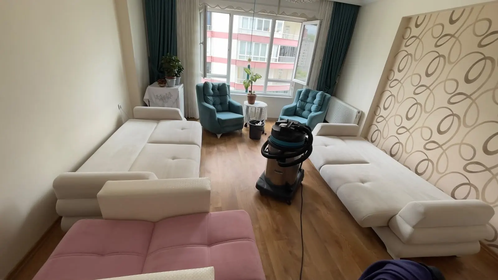 Bir evin salonunda koltuk takımı yıkaması, yanında yıkama makinesi